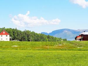 Un campo de césped verde con una casa y un granero en 6 person holiday home in ALSVÅG-By Traum, en Gisløy