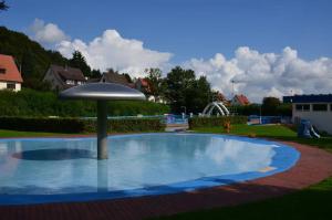 a small pool with an umbrella in a yard at Gästehaus Laßbruch in Extertal