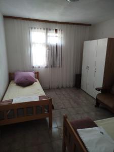 a small bedroom with two beds and a window at Apartmani Katarina in Rogoznica