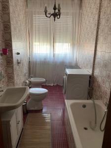 a bathroom with a sink and a toilet and a tub at Appartamento Mare Monti in Carrara
