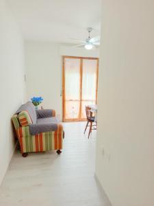 a living room with a couch and a ceiling fan at ROSA BLU House in Pisa