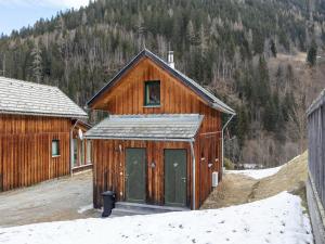 a wooden building with a door in the snow at Chalet in Stadl near Kreischberg Ski Area in Stadl an der Mur