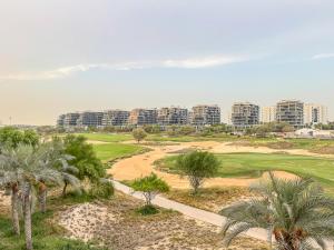 una vista aerea su un campo da golf con palme di Savis Homes - Furnished Spacious Studio in Golf Promenade 2A by Damac Hills a Dubai