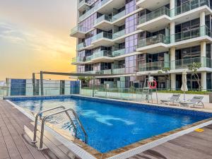 una piscina di fronte a un edificio di Savis Homes - Furnished Spacious Studio in Golf Promenade 2A by Damac Hills a Dubai