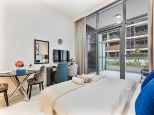 una camera con un grande letto e una scrivania con un computer di Savis Homes - Furnished Spacious Studio in Golf Promenade 2A by Damac Hills a Dubai Altre 52 foto