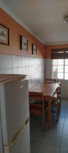 a kitchen with a wooden table and a refrigerator at Leuchars Guest House in Greytown +23 photos
