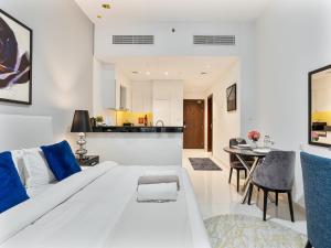 un soggiorno con un divano bianco e un tavolo di Savis Homes - Furnished Spacious Studio in Golf Promenade 2A by Damac Hills a Dubai
