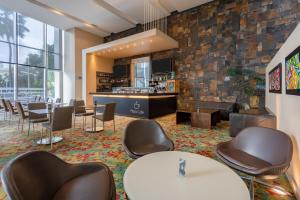 a waiting room with chairs and tables and a bar at Estelar Apartamentos Barranquilla in Barranquilla