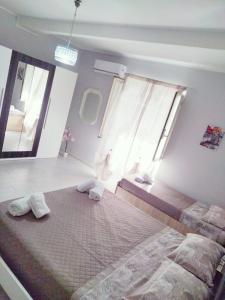 a bedroom with two beds and two windows at Dimora dello Stretto Intero Appartamento 4 posti Self Check-in Cucina Lavatrice Vicino Policlinico in Messina