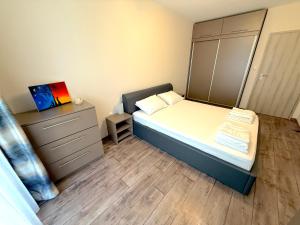 une petite chambre avec un lit et une commode dans l'établissement Уютен двустаен Гранд мол, à Varna