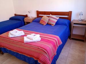 two beds with towels on them in a room at La Carmela, Tilcara in Tilcara