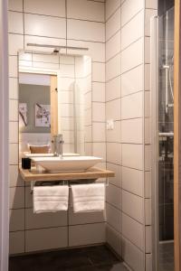 a bathroom with a sink and a mirror at Hôtel restaurant Vertfeuille in Arc-et-Senans