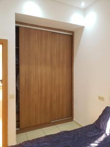 Cette chambre comprend un placard avec une porte en bois. dans l'établissement Sea View Apartment, à Sidi Bouqnadel 3 autres photos