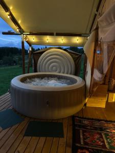 a large tub sitting on a deck in a tent at Hutsul Glamp Панорамний вид Джакузі Best Sunset in Mykulychyn