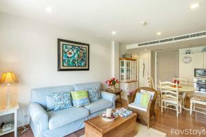 a living room with a blue couch and a table at Baan Nub Kluen Condo - Hua Hin in Ban Khao Takiap