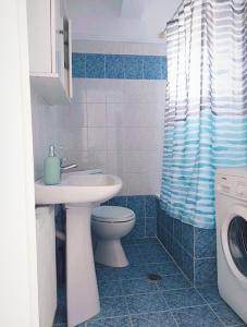 a bathroom with a sink and a toilet and a washing machine at Isolde Apartment in Kallithea Halkidikis +24 photos