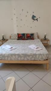 a bed in a room with two tables and a chair at Casa Ariel in Avola