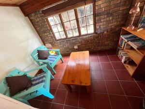 een woonkamer met een houten tafel en stoelen bij The Berg Surf Shack in Muizenberg