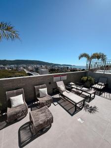 a patio with chairs and tables on a roof at Apartamentos Elegance 413 in Bombinhas