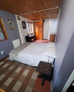 een slaapkamer met een bed en een tafel erin bij The Berg Surf Shack in Muizenberg +27 foto's