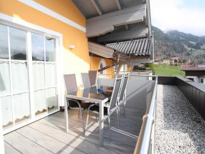 eine Terrasse mit Tisch und Stühlen auf einem Balkon in der Unterkunft Mansion in Goldegg near Ski Lift in Goldegg