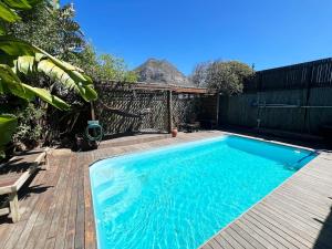 a swimming pool on a wooden deck next to at The Berg Surf Shack in Muizenberg