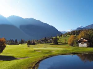 ein Golfplatz mit einem Teich und Bergen im Hintergrund in der Unterkunft Mansion in Goldegg near Ski Lift in Goldegg