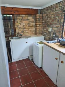 een keuken met een spoelbak en een wasmachine bij The Berg Surf Shack in Muizenberg