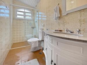 une salle de bain avec toilettes, lavabo et douche dans l'établissement Lareira Jacuzzi 1 suíte Churrasqueira Wi-Fi, à Campos do Jordão 40 autres photos