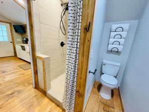 a bathroom with a toilet and a shower at Jai Hollow Tiny Home Cottage in Robbinsville +38 photos