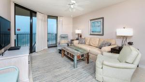 d'un salon avec un canapé et des chaises ainsi que d'un balcon. dans l'établissement Phoenix V 715, à Orange Beach