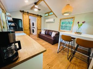 a kitchen and living room with a couch and a table at Jai Hollow Tiny Home Cottage in Robbinsville