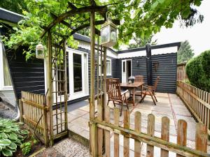 a garden with a pergola and a table on a patio at Chalet in Veluwe near Sauna Drôme in Putten