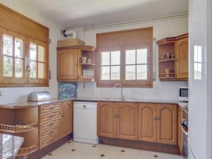 een keuken met houten kasten en een spoelbak bij Villa in Arenys de Mar with Sea View in Arenys de Mar