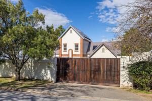 una casa con un cancello in legno e una recinzione di 6 Durban Street, Grahamstown a Grahamstown