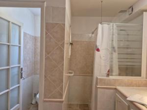 a bathroom with a shower with a shower curtain at Le nid des agrumes in Lucciana +18 photos