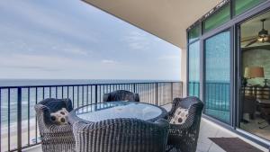 a balcony with a table and chairs and the ocean at Phoenix West 1103 in Orange Beach