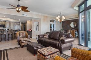 a living room with a leather couch and chairs at Phoenix West 1103 in Orange Beach