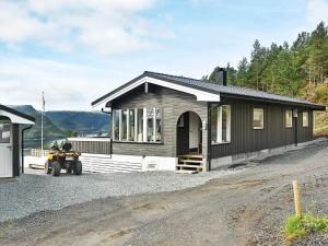 una pequeña casa con una motocicleta estacionada frente a ella en 8 person holiday home in Sundlandet, en Snildal