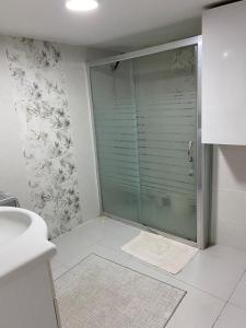 a bathroom with a shower with a glass door at Star Apartment Derya Izmir in Konak +8 photos