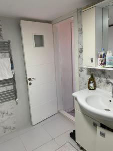 a white bathroom with a sink and a door at Star Apartment Derya Izmir in Konak