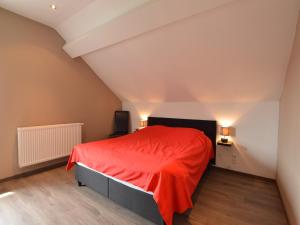 Un dormitorio con una cama roja en un ático. en Holiday Home in La Roche en Ardennes, en La-Roche-en-Ardenne 24 fotos más