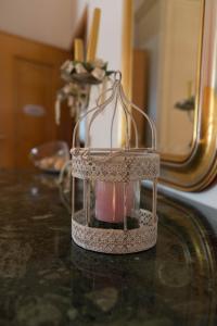 une cage à oiseaux posée sur une table devant un miroir dans l'établissement Sa Mama e Su Sole, à Alghero