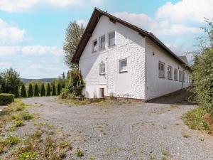 a white building with a driveway in front of it at Ferienwohnung in der Nähe von Skipisten in Winterberg