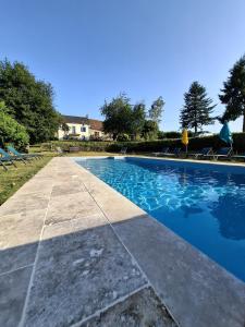a swimming pool with blue water in a yard at Les Marronniers Gîtes in Crozant