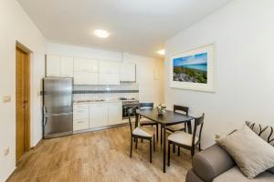 - une cuisine et une salle à manger avec une table et un canapé dans l'établissement Apartment Lili, à Biograd na Moru