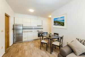 a kitchen and dining room with a table and a couch at Apartment Lili in Biograd na Moru