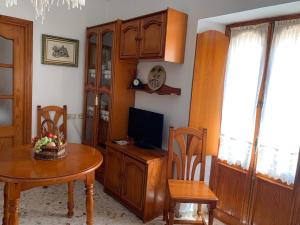 a dining room with a table and a tv at Casa Ana in Vejer de la Frontera