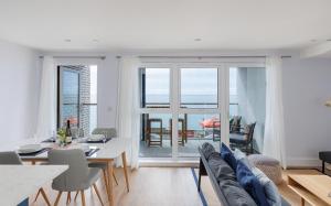サンダウンにあるCulver Sands - Duplex Apartment with Stunning Sea Views on the Isle of Wightのソファとテーブルと椅子のあるリビングルーム