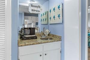 eine Küche mit einer Spüle und einer Kaffeemaschine auf der Theke in der Unterkunft Plantation 1211 in Gulf Highlands